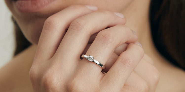 Verlobungsring in Weißgold mit Diamant-Solitär an Damenhand, eleganter Verlobungsschmuck