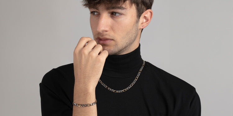 Stylischer Mann präsentiert silbernes Schmuck-Set: Panzerkette und Armband - moderner Männerschmuck