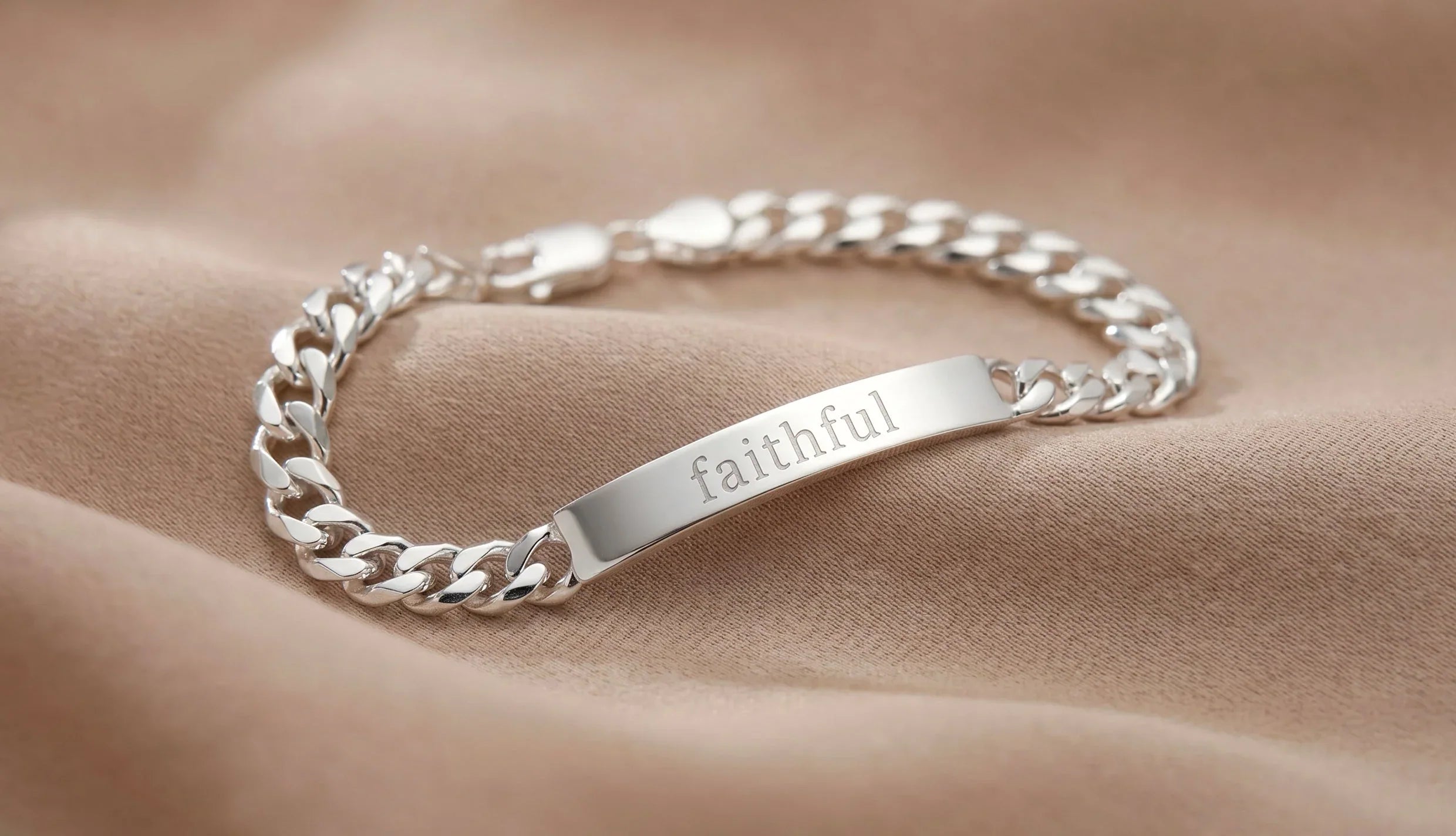 Silbernes Panzerarmband mit Gravurplatte am Handgelenk getragen